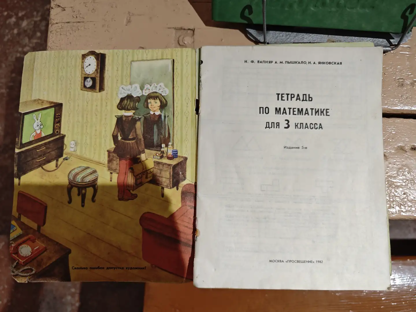 一本打开的数学练习册，左侧页面是一幅插图，画着一个女孩站在梳妆台前，电视里播放着兔子动画。右侧页面写着“ТЕТРАДЬ ПО МАТЕМАТИКЕ ДЛЯ 3 КЛАССА”以及出版信息“МОСКВА «ПРОСВЕЩЕНИЕ» 1982”。书页下方有小字提示“Сколько ошибок допустил художник?”