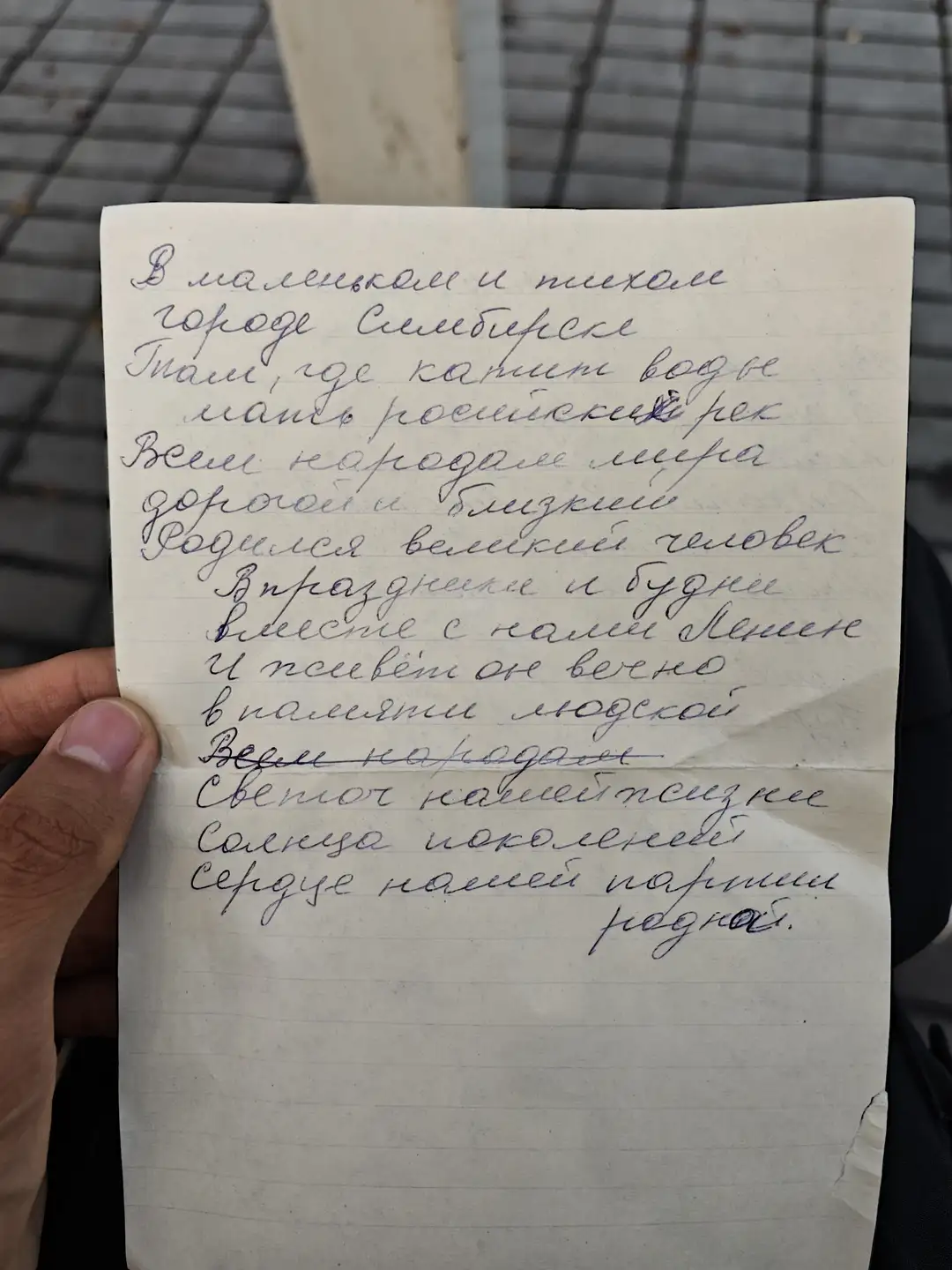 一张纸上的手写俄文诗描述了在西伯利亚小镇乌拉尔河畔，一位伟人诞生，他与列宁一同庆祝并歌唱，成为人民心中的光明，照亮了无数代人的心灵。