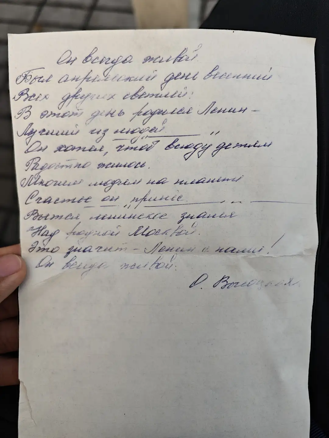 一张纸上的手写俄文诗讲述了一个安静的春天早晨，列宁诞生的日子，人们在阳光下欢庆，许多城市因他的名字而得名，他永远活在人民心中。