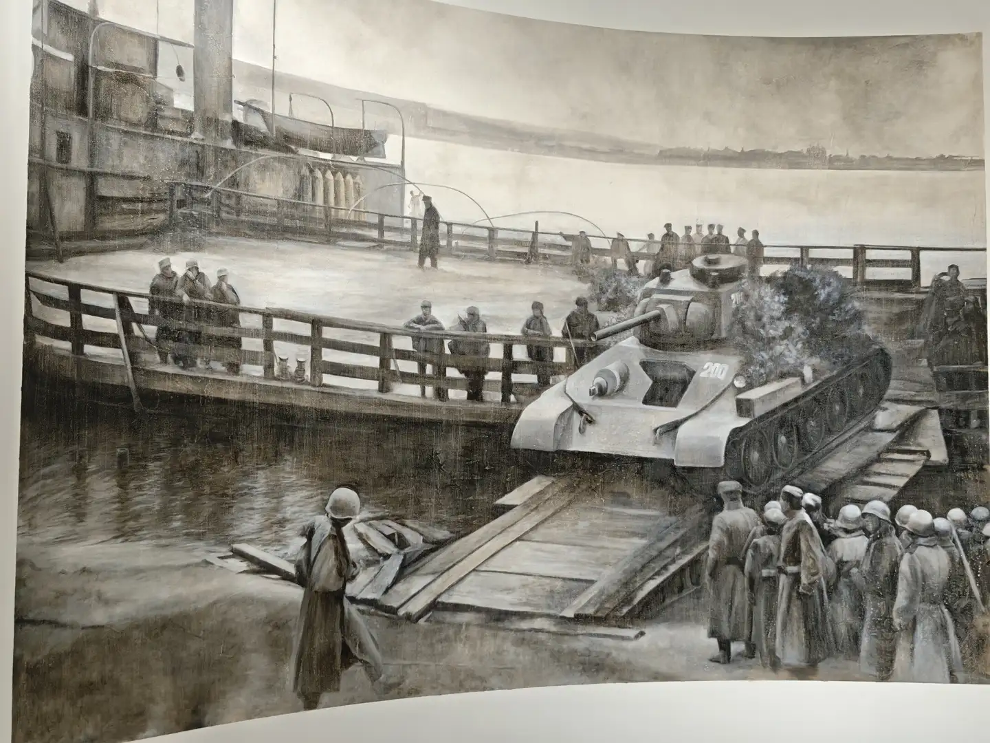 一幅描绘坦克登陆场景的画作，坦克正从驳船上驶向岸边，周围有士兵列队观看。水面上有木制跳板连接船只与陆地，背景中可见码头设施和远处的河岸。画作以灰暗色调呈现，突显出战争时期的沉重氛围。