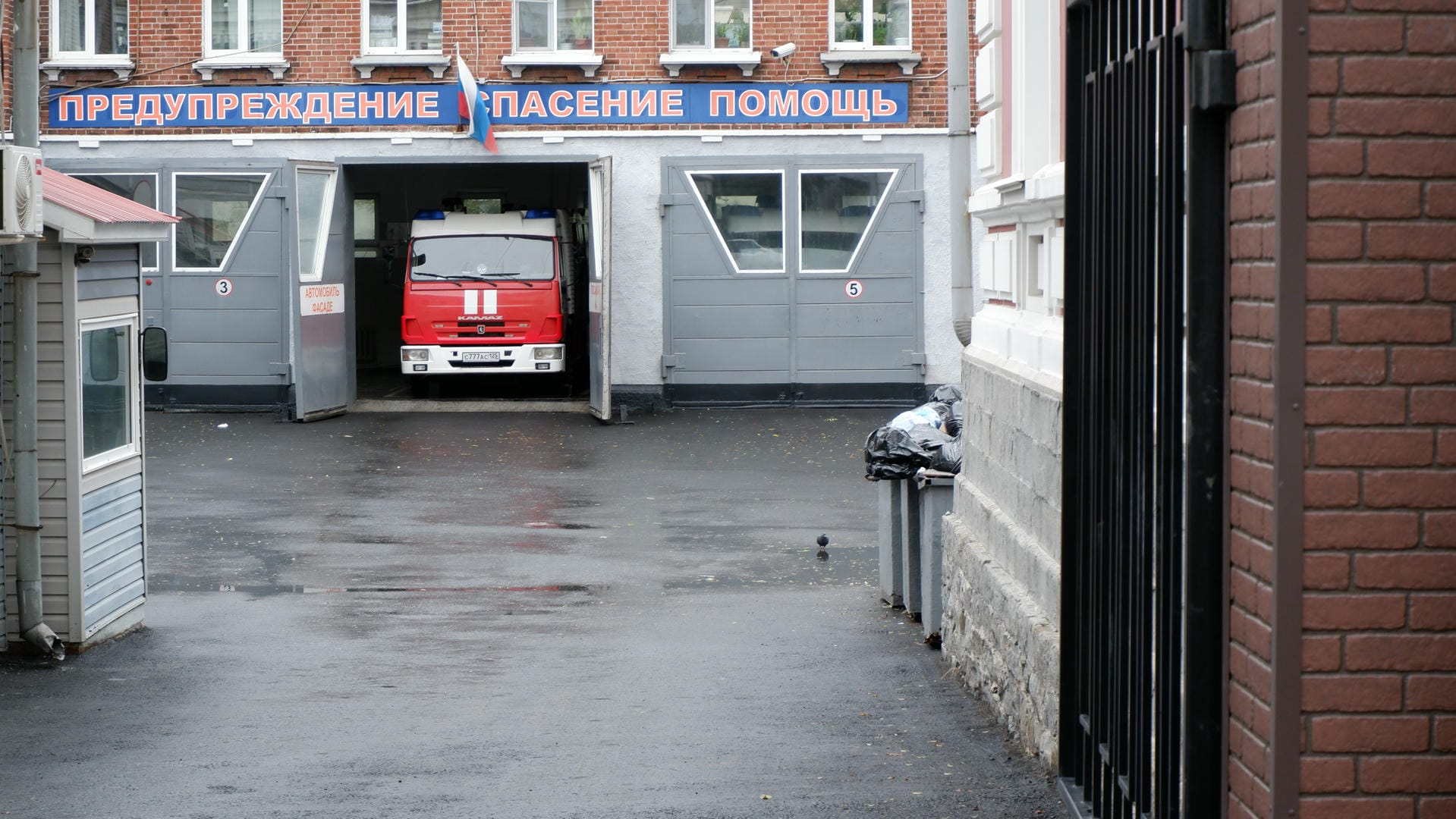 Cars lining both sides of the street, with a row of red brick buildings on the left.