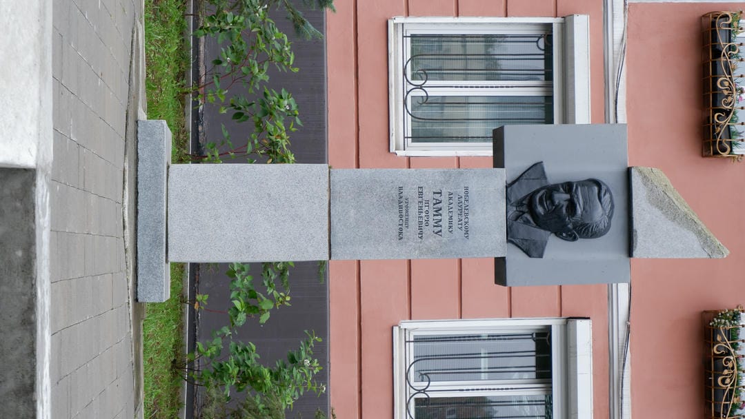 A red firetruck parked near a garage entrance, surrounded by trash bins.