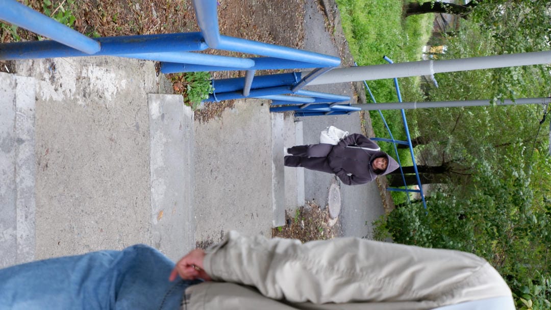 A monument standing on the sidewalk, engraved with text and relief sculptures.