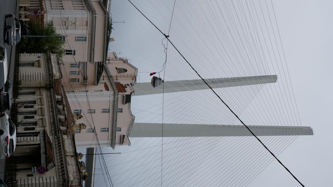Two towering bridge pylons reaching into the sky, with classical-style architecture beneath the bridge.