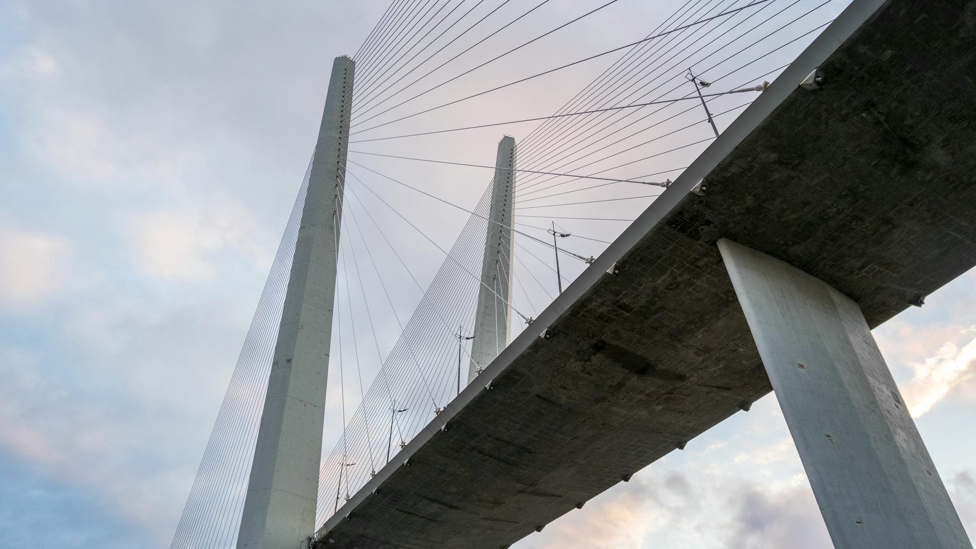 Close-up of bridge structure showing concrete pillars and stay cables supporting the deck.