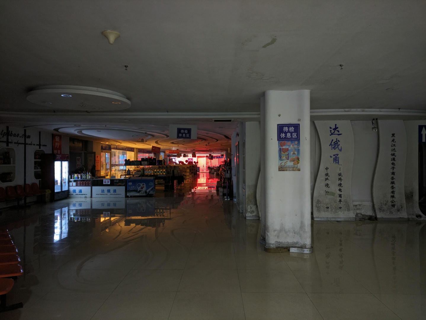 Dimly lit interior with multiple counters and Chinese signage on walls.