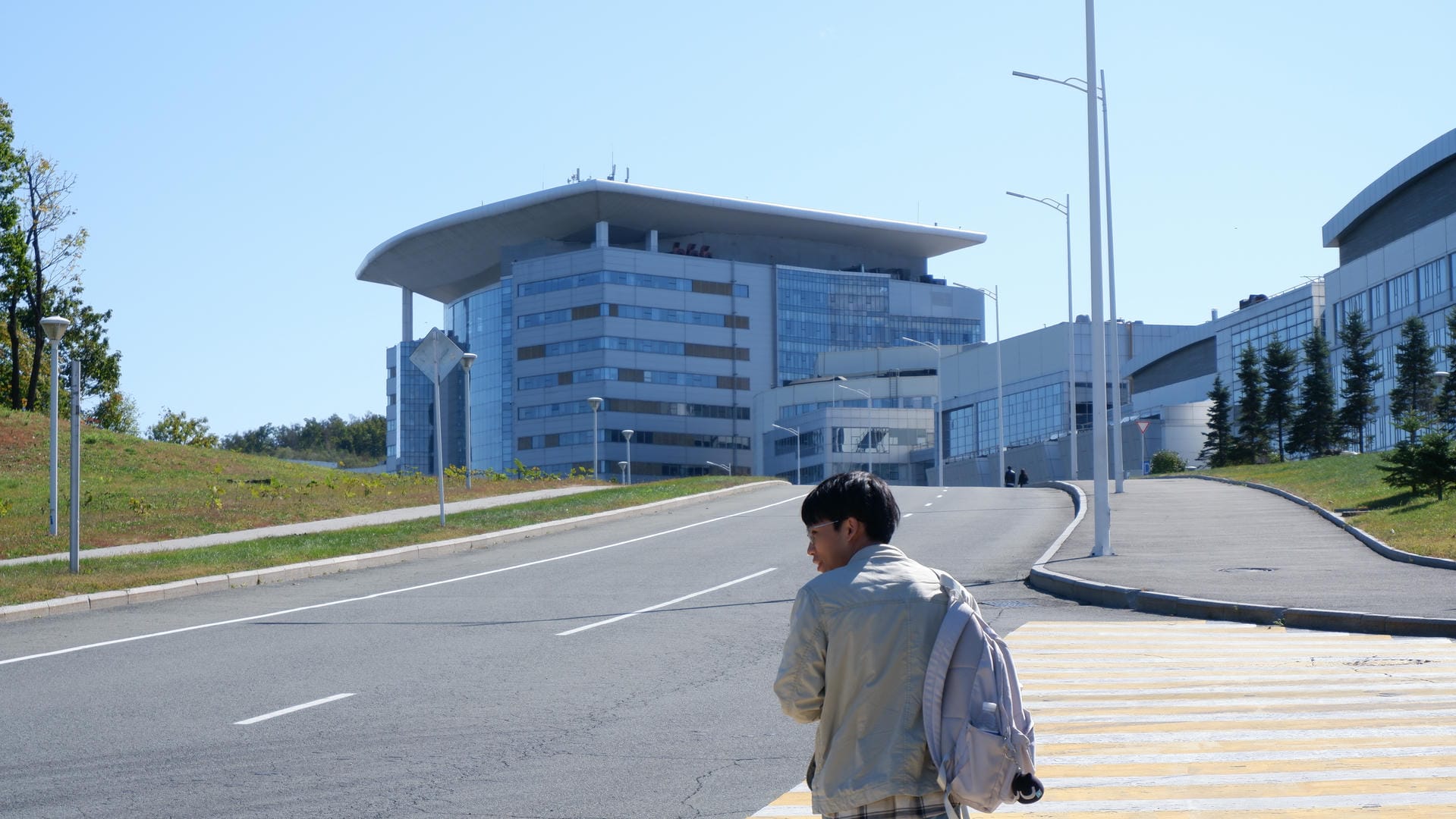 Backpacker walking toward modern building.