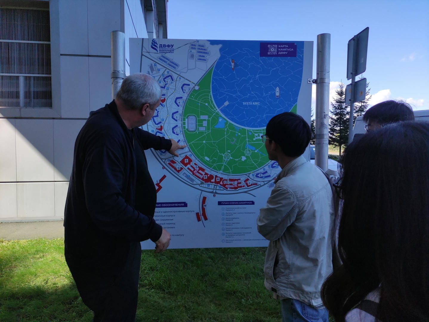 Group examining outdoor map showing blue/green zones.
