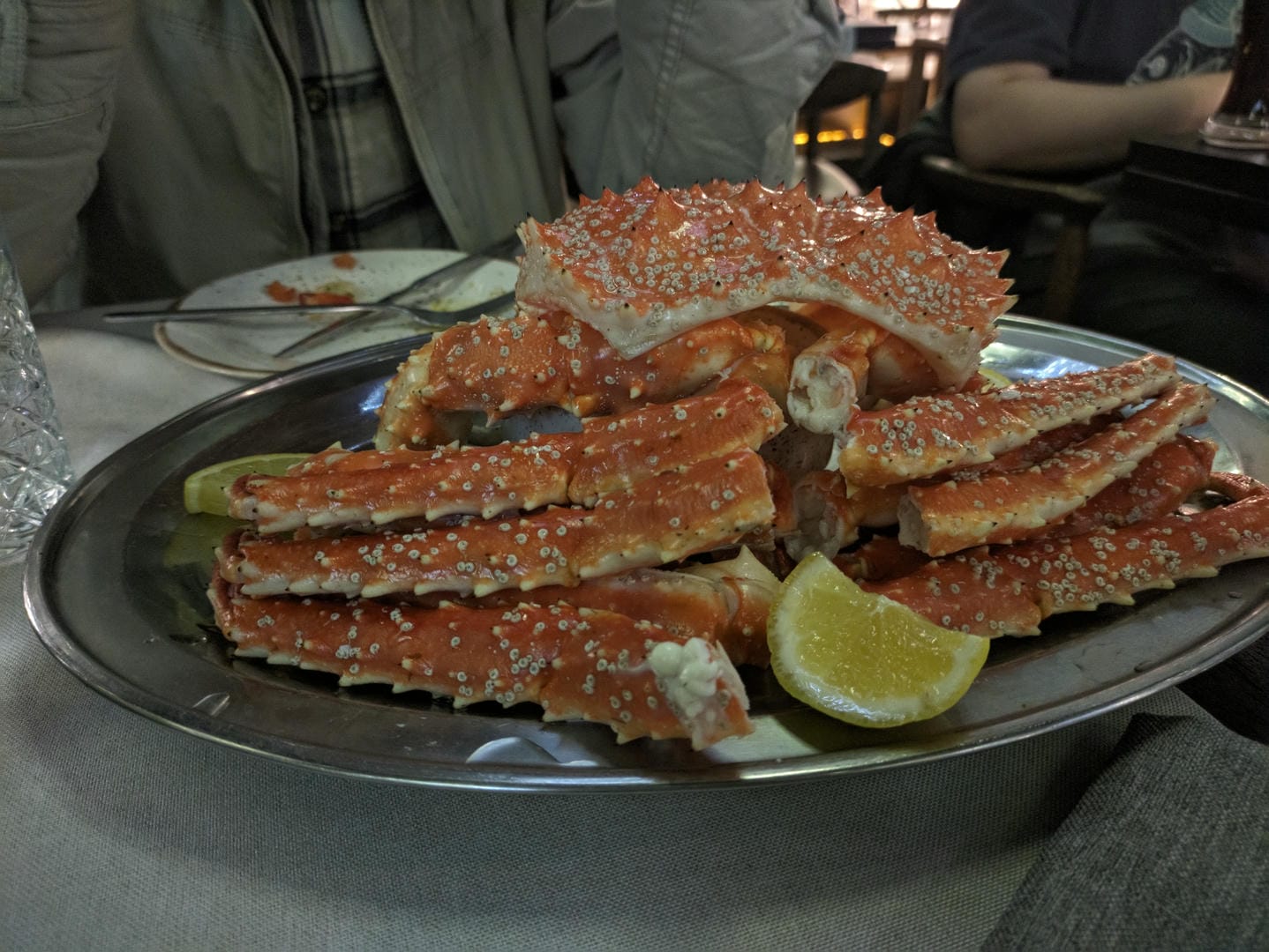 King crab legs on silver plate with lemon slice.