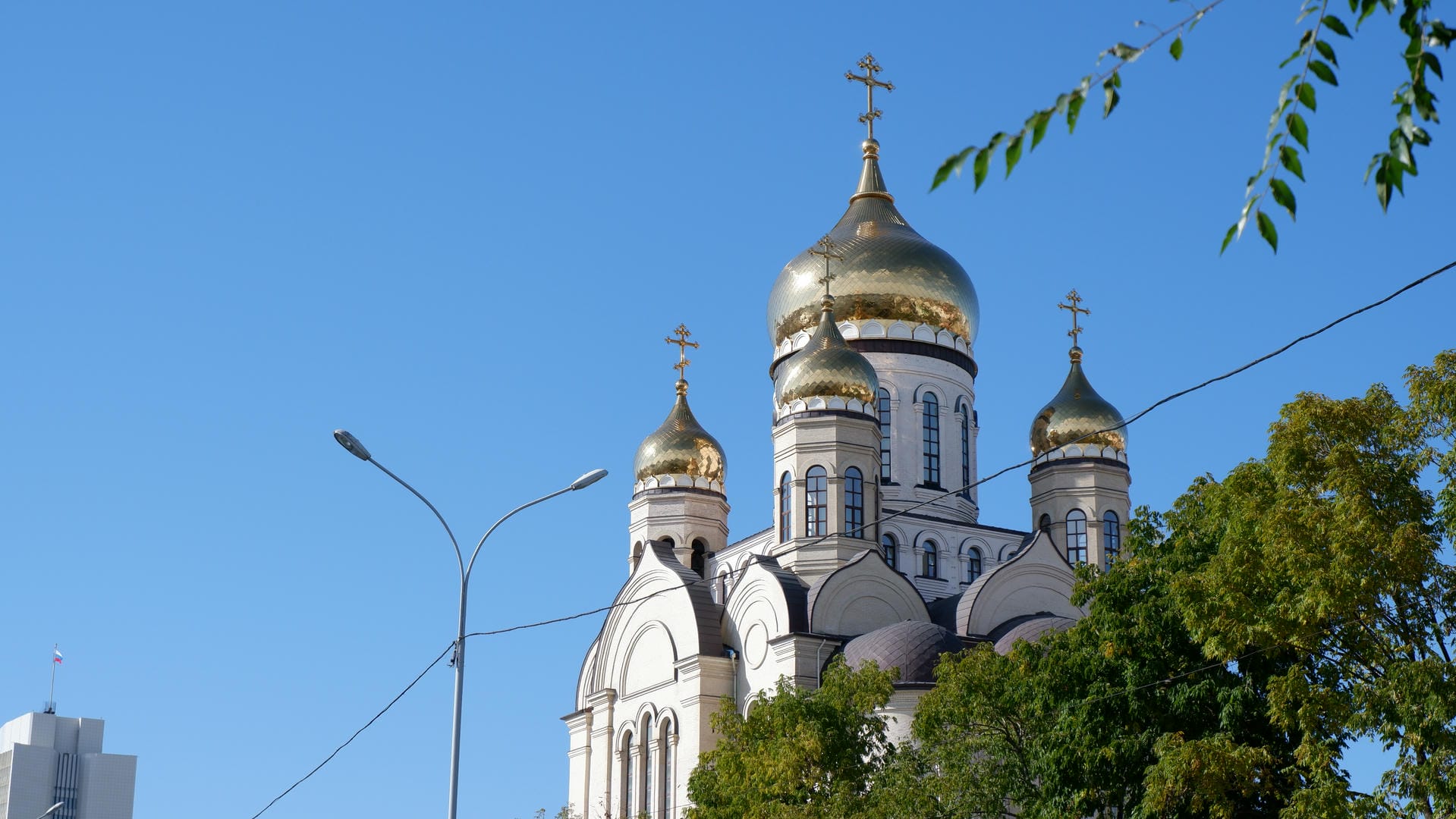 A golden-domed church surrounded by trees and lampposts.