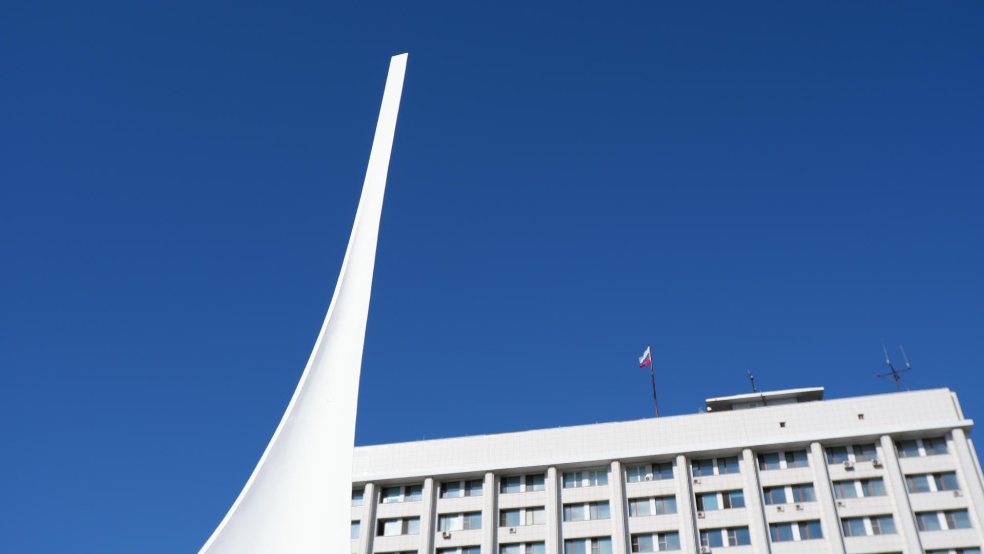 A white spire building with the Russian flag flying at the top.