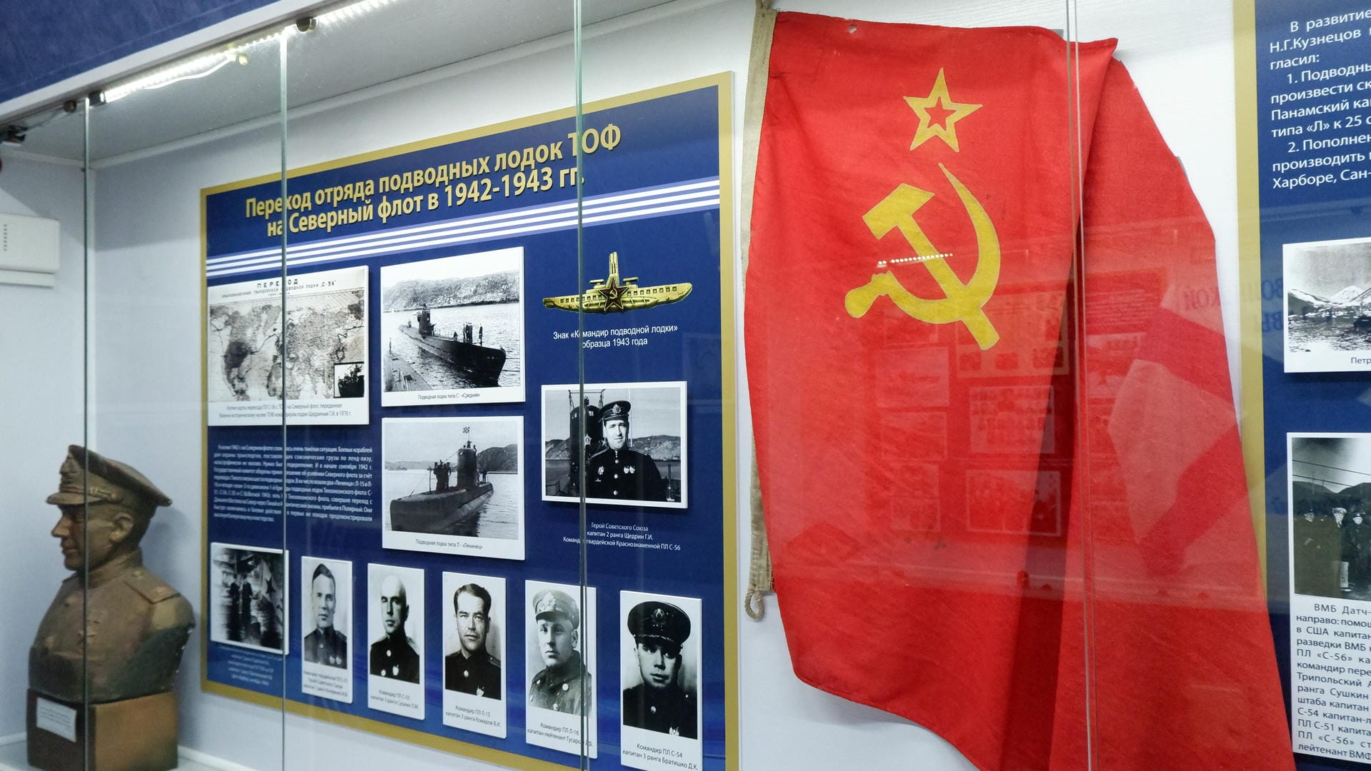 A Soviet flag hangs on the wall, next to photos of submarines and soldiers.