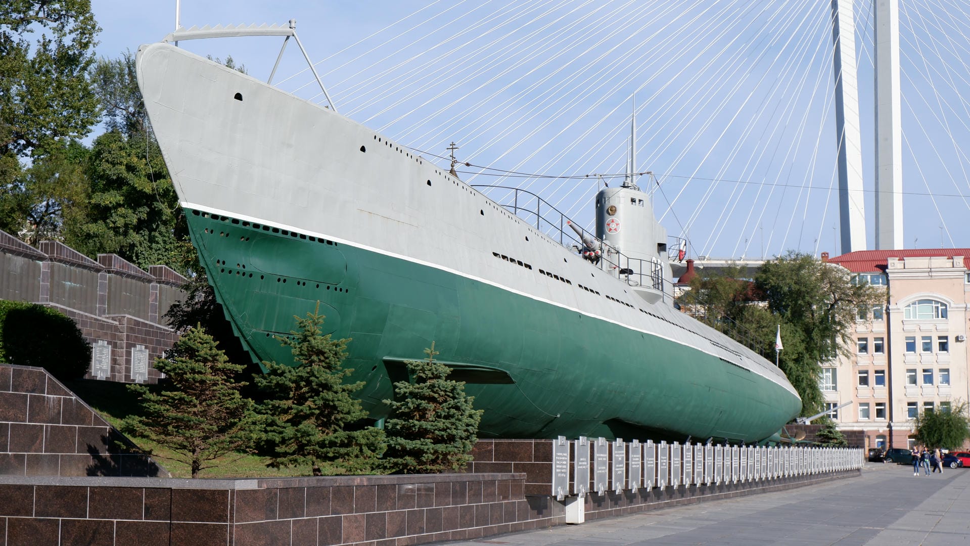 A modern building with a facade made of glass and white materials, topped with a red roof.
