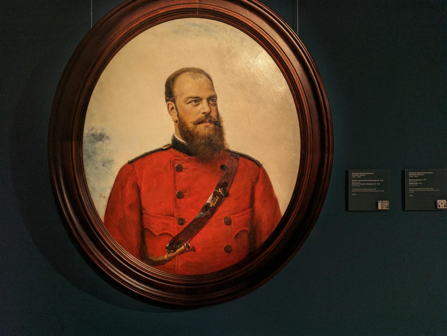 A circular framed portrait depicts a bearded man in a red military uniform.