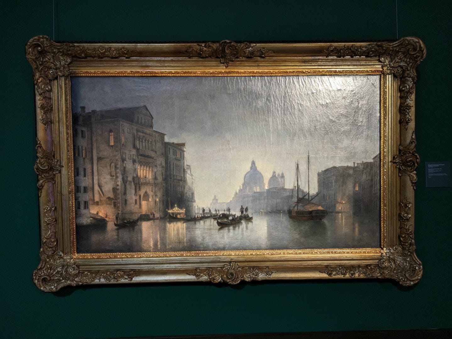 A painting depicts a night view of Venice’s canals, with brightly lit buildings along the water.