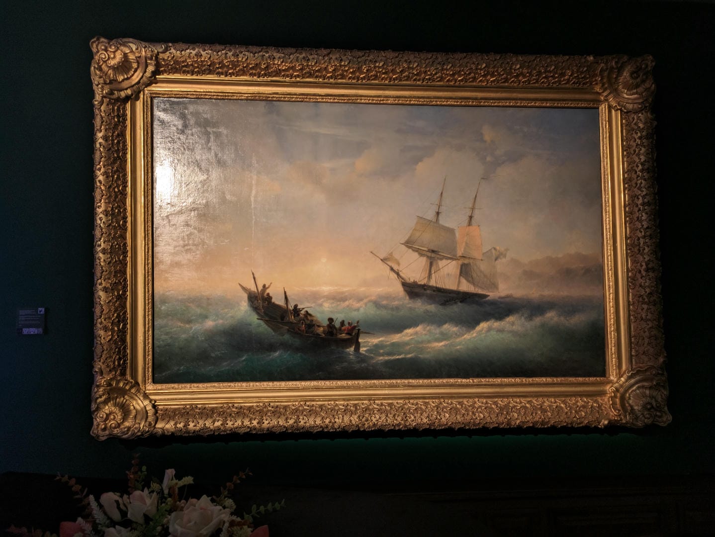 A painting depicts a storm at sea, with two ships navigating turbulent waters.