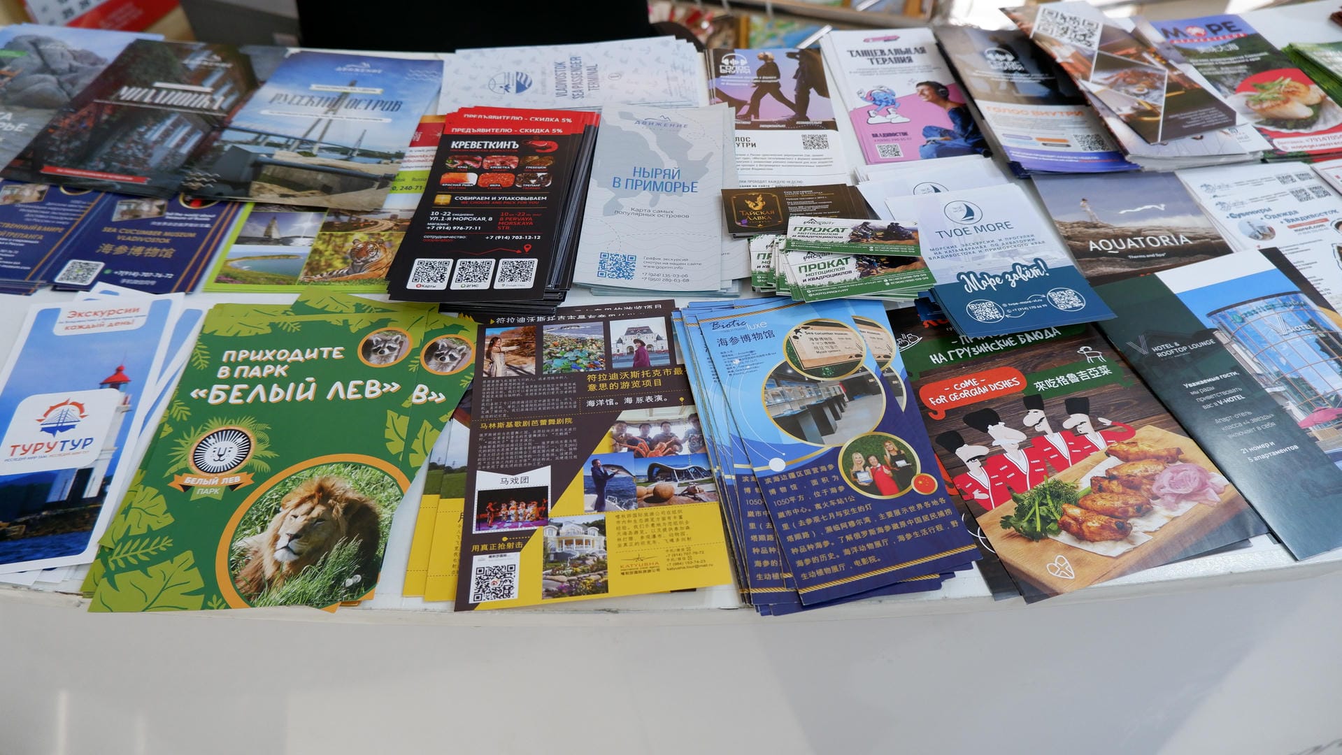 Various tourism brochures and maps are displayed on a table, covering multiple attractions.