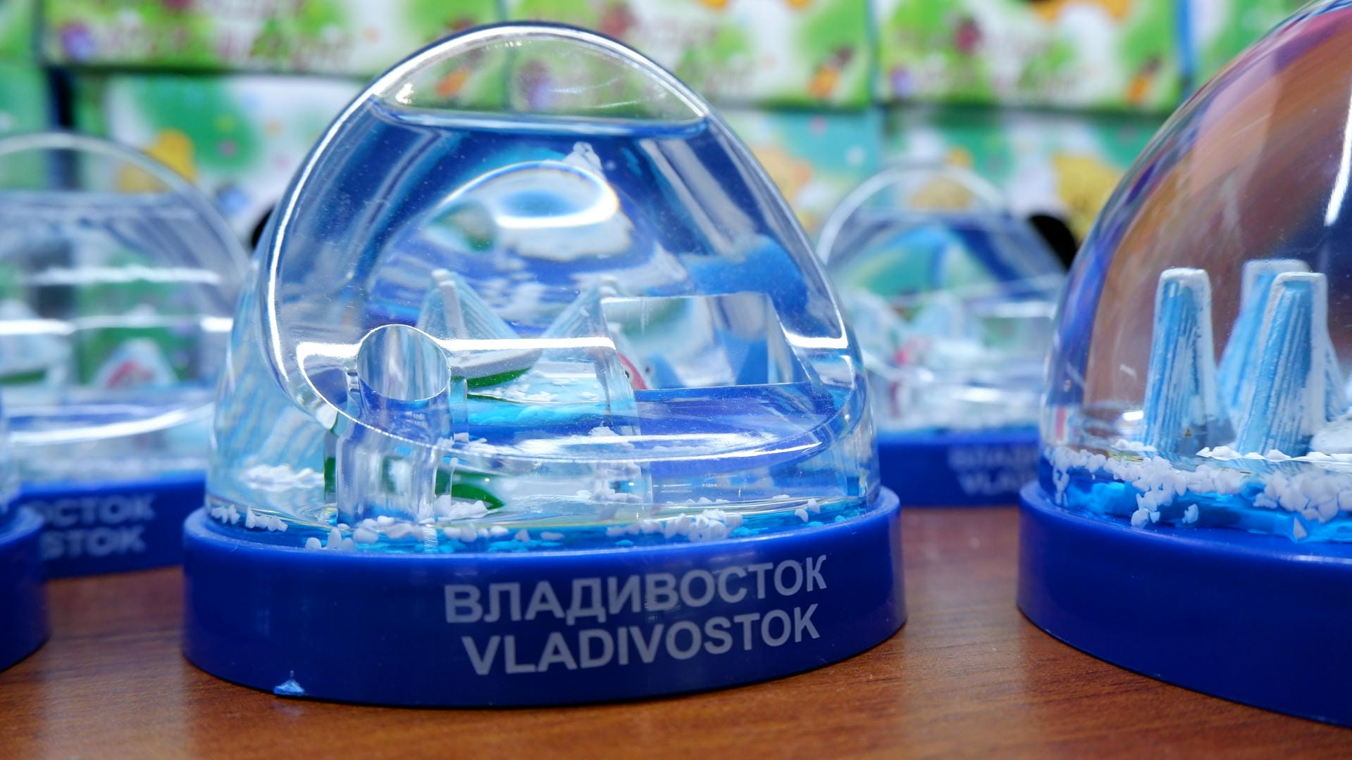 A transparent crystal ball contains a miniature architectural model, with “VLADIVOSTOK” printed at the base.