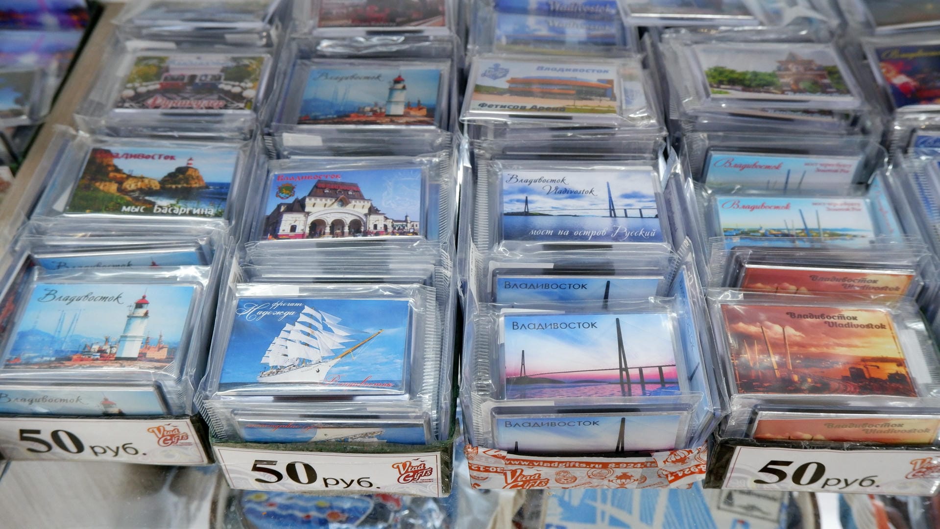 Multiple postcards are neatly arranged in plastic bags, each featuring different landscape paintings.