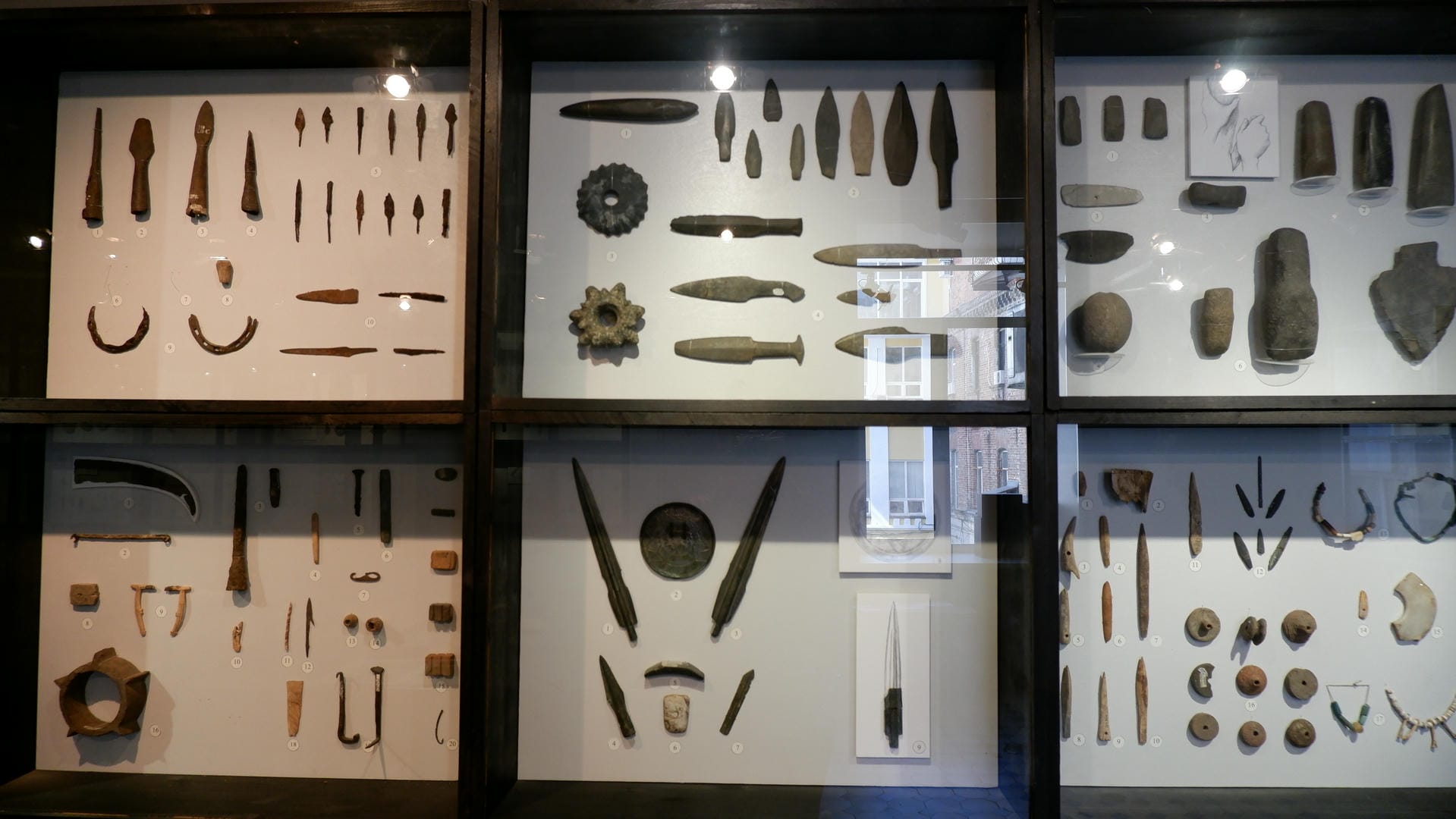 Six display cases contain various ancient tools and weapons.
