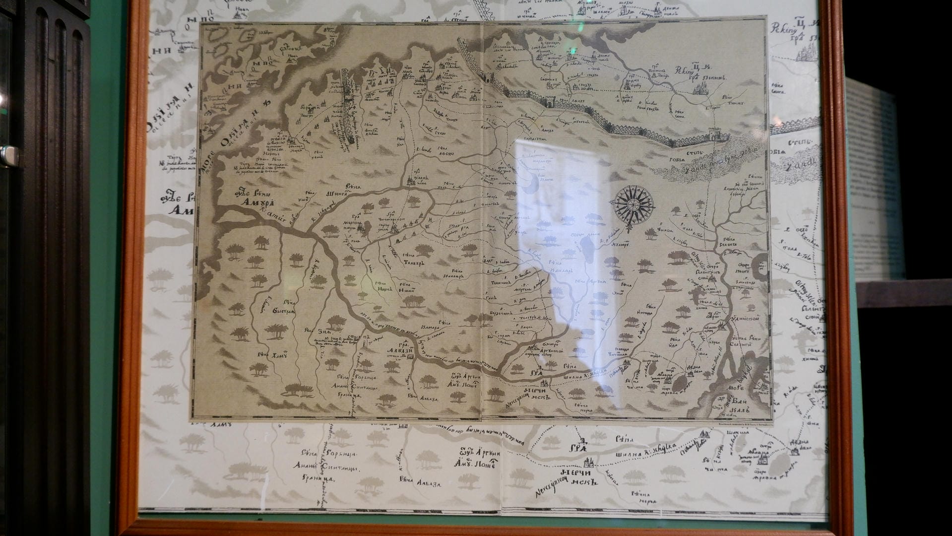An old map detailing rivers, mountains, and towns, framed and mounted.
