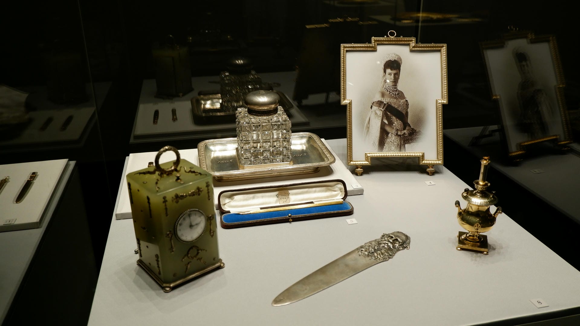 A clock, an inkwell, a knife, a candlestick, and a photograph.