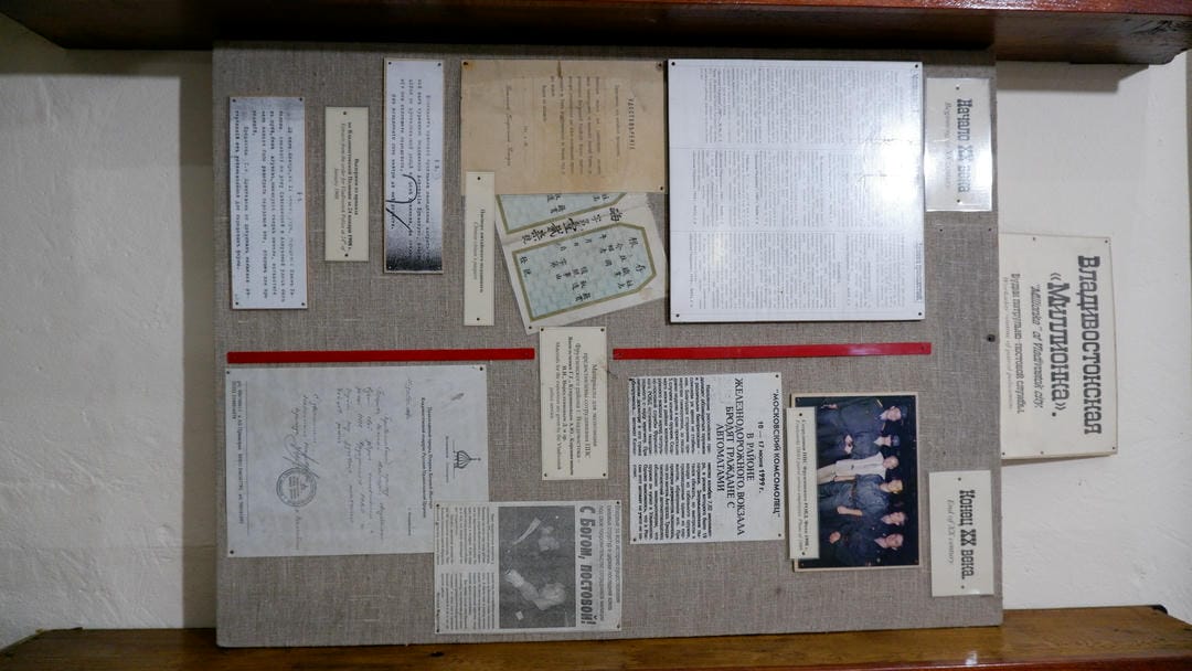 A display board featuring various documents, photos, and text descriptions, with a title plate at the top.