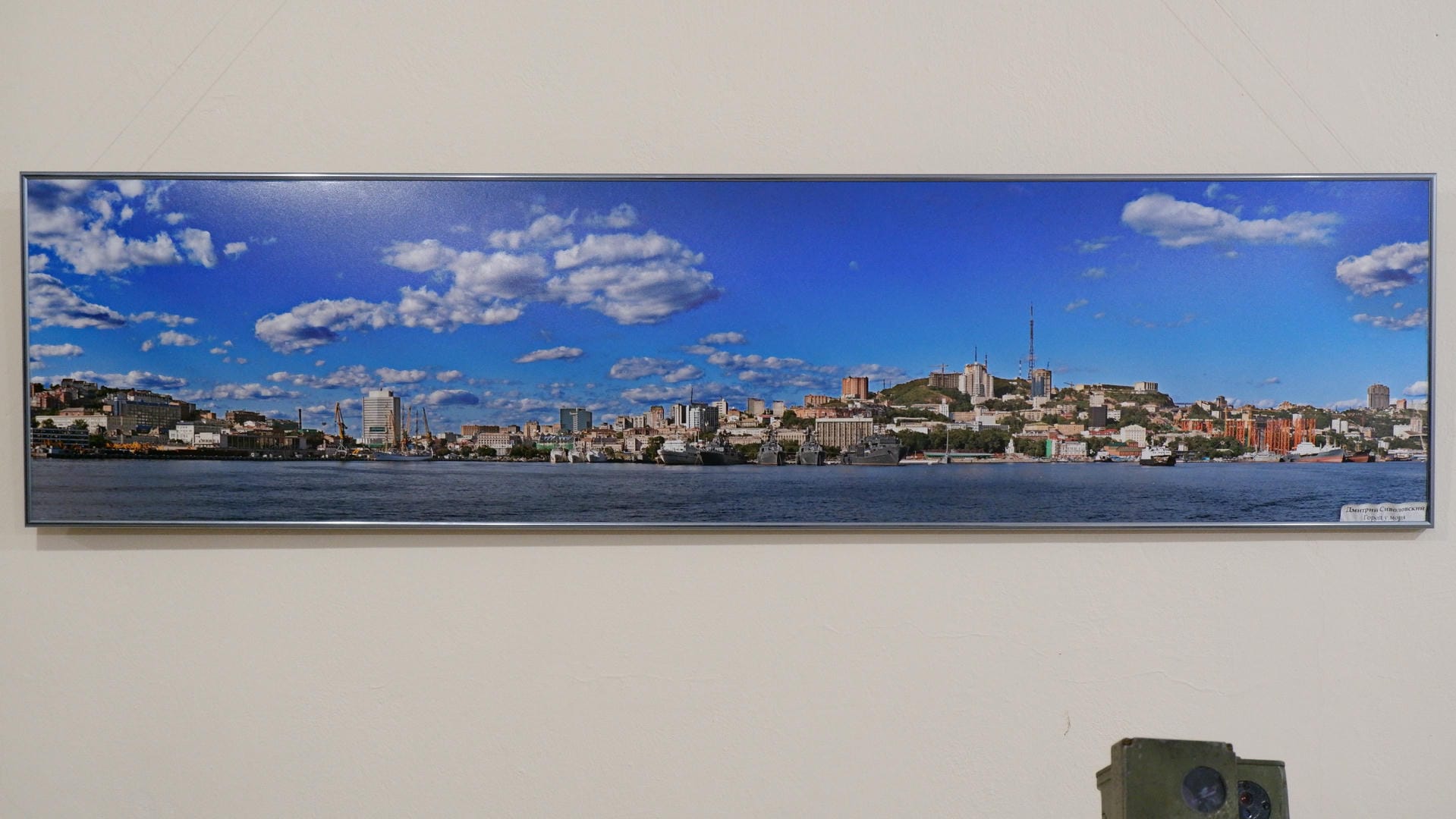 A panoramic view of a city showcasing buildings and rivers under a blue sky with white clouds.