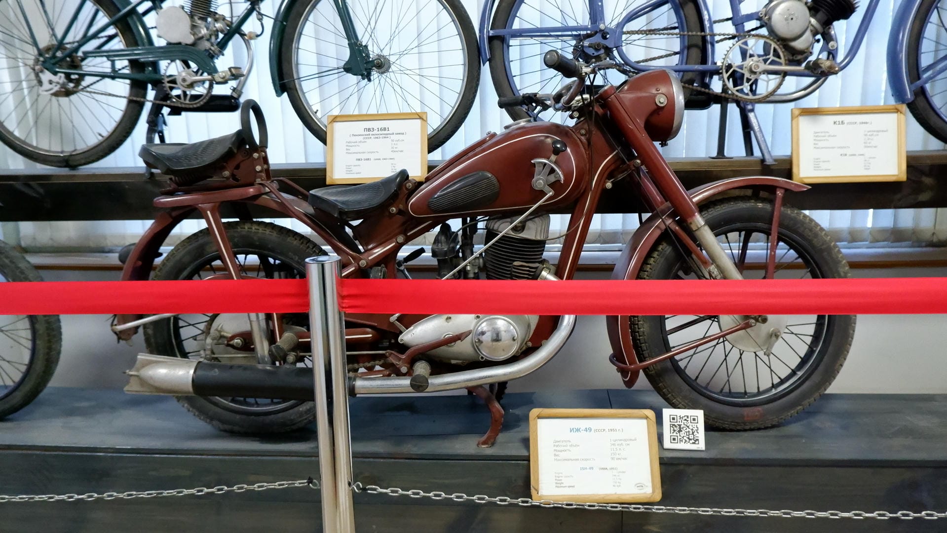 A red motorcycle with silver frame and rims, and a black seat.