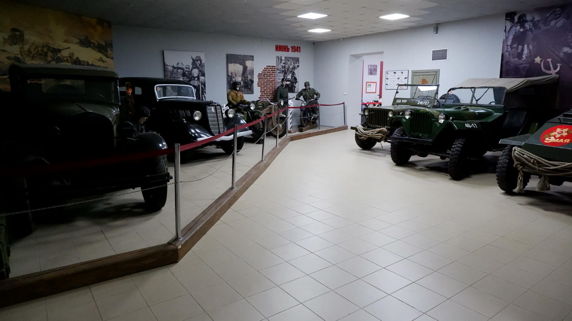 An exhibition hall displaying multiple military vehicles and motorcycles.