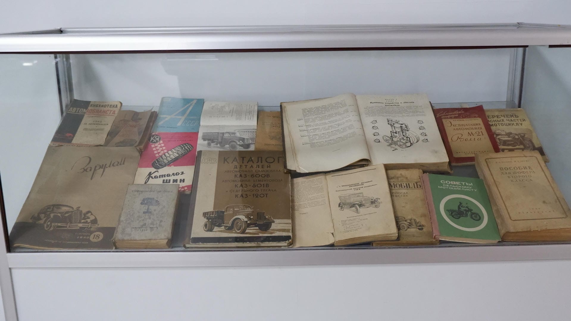 Bookshelves filled with old books, covers showing content related to cars and motorcycles.
