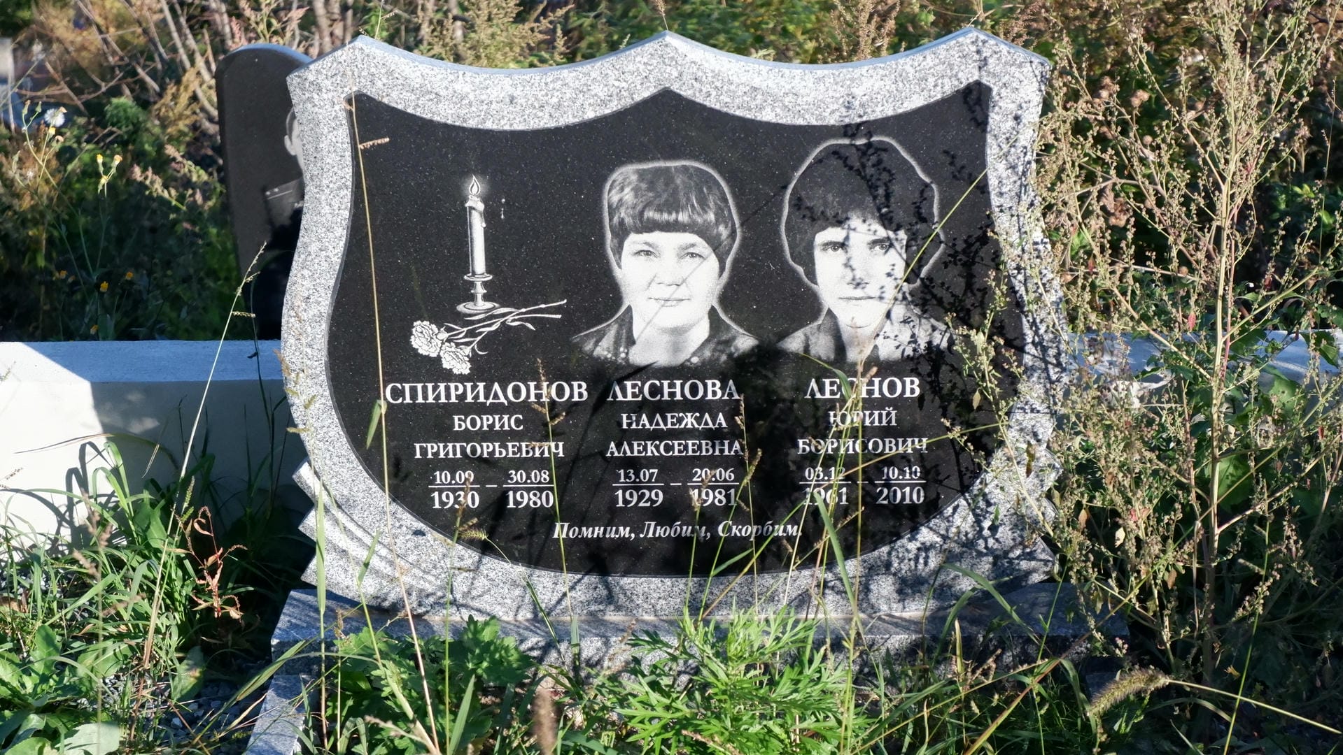 A tombstone with photos and names of three members of the Spiridonov family.