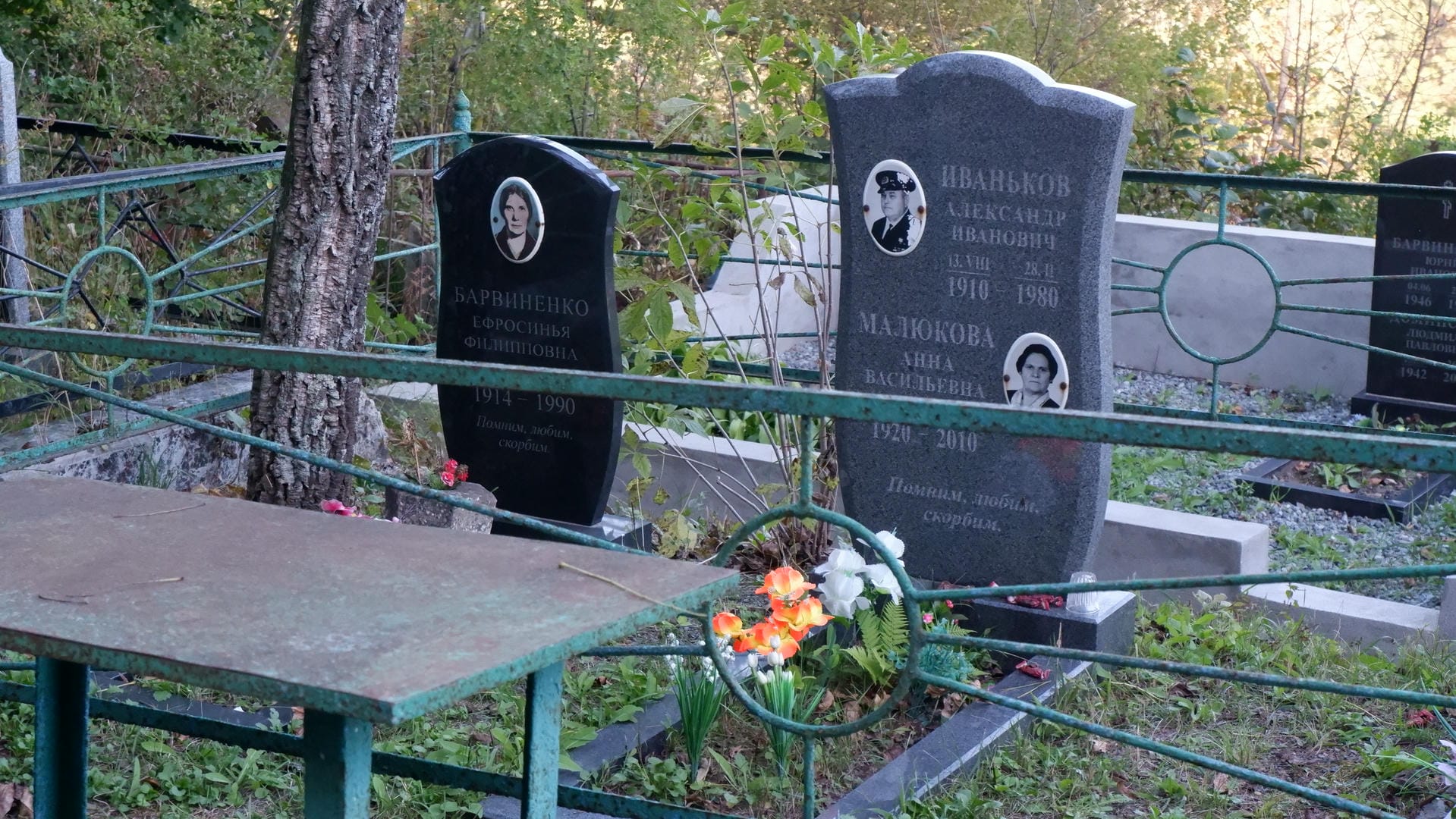 Two tombstones respectively engraved with photos and birth-death years of Yefrosinya Barvintseva and Alexander Ivanov.