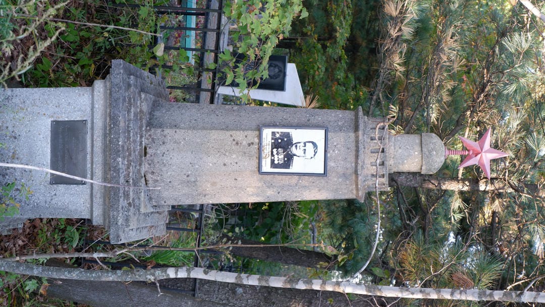 A column topped with a red five-pointed star, with a soldier’s photo embedded in the middle.