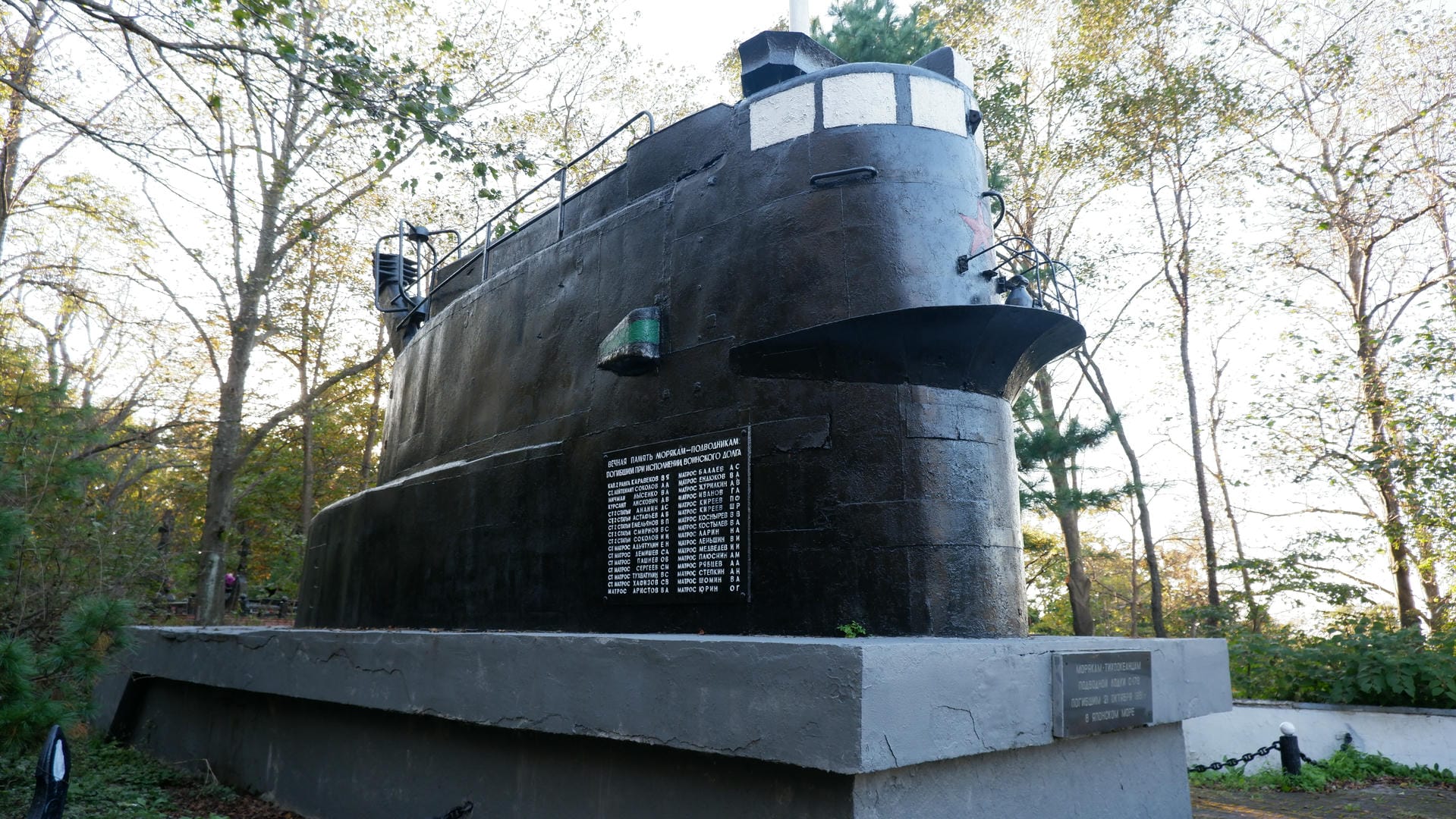 The monument features a submarine-shaped structure with inscriptions on the side.