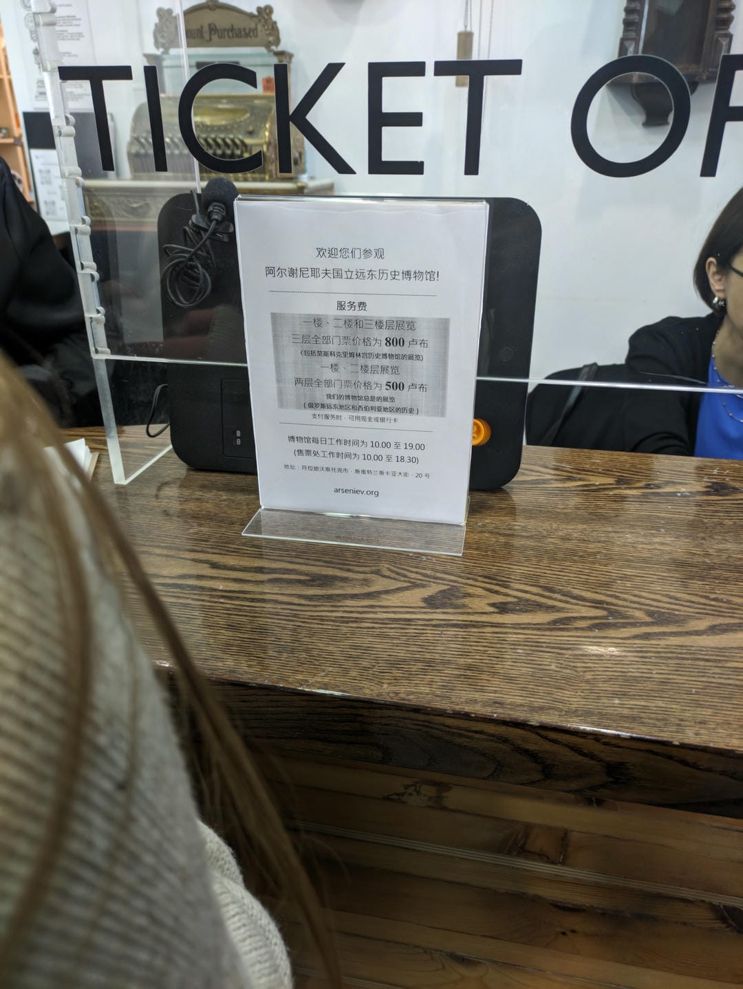 A Chinese notice board with information about visiting the museum and ticket prices is placed in front of the ticket office.