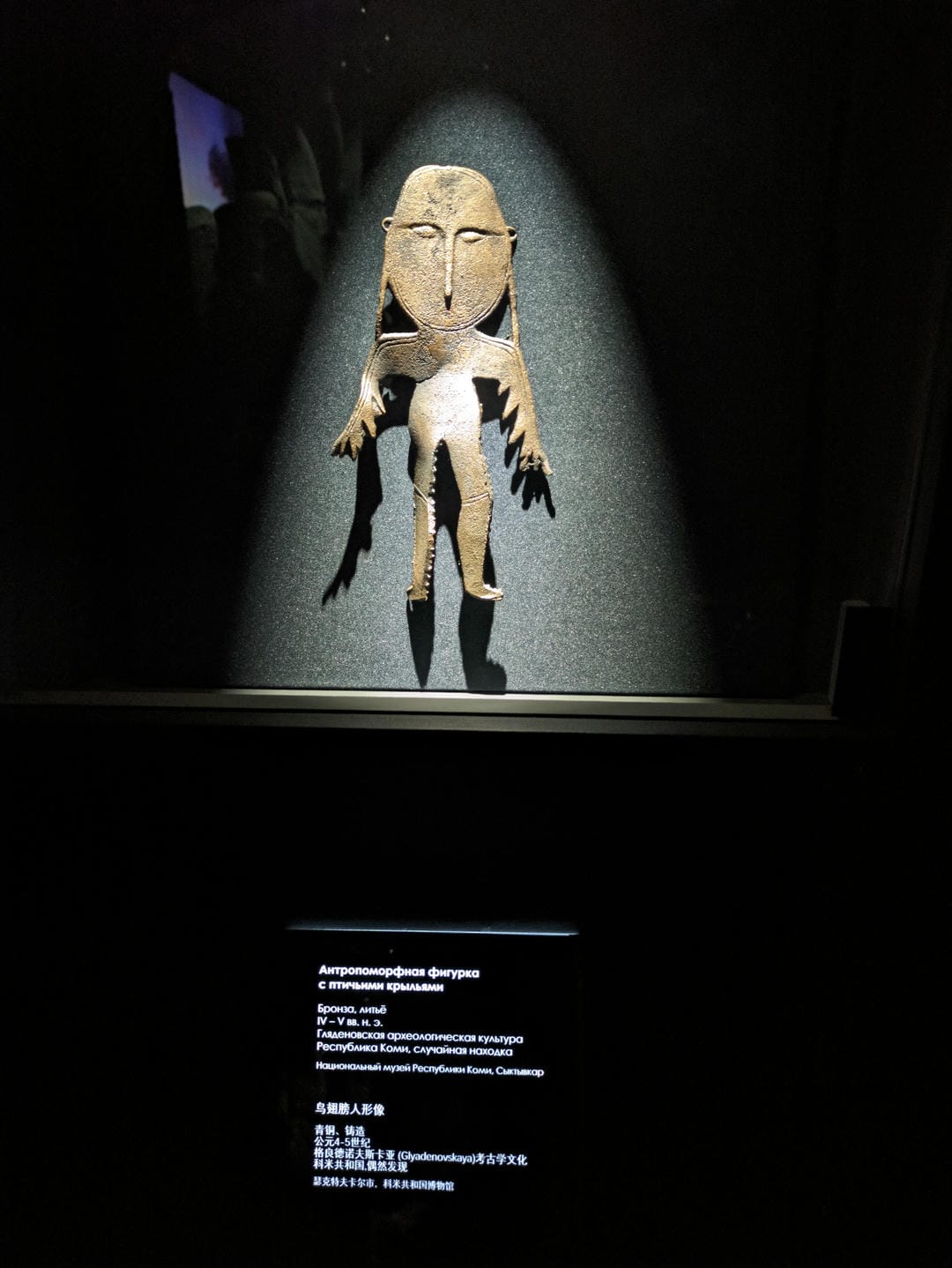 A human-shaped statue illuminated by lights, with a black background.