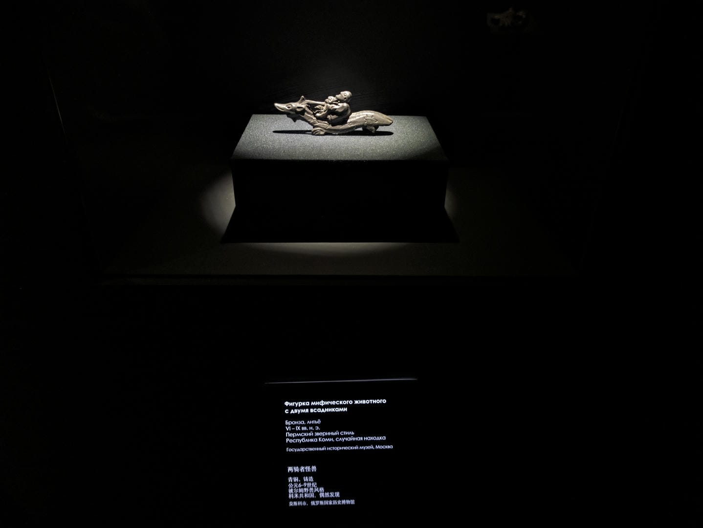 A small bronze sculpture depicting two people riding animals.