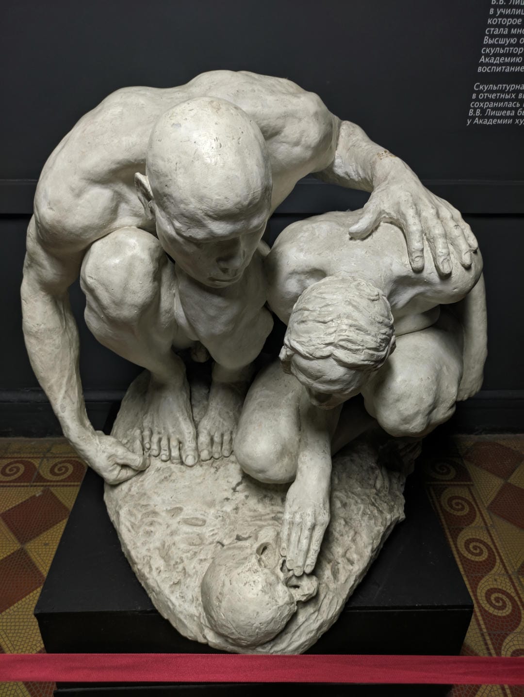 A white sculpture depicting an adult male and a child.