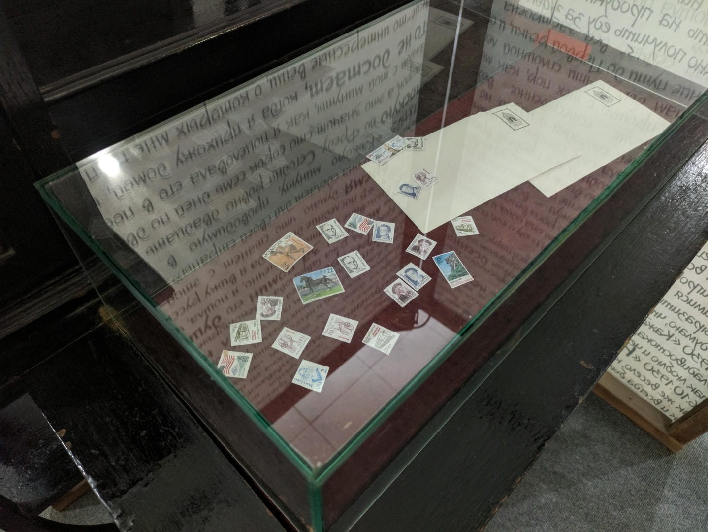 Stamps and envelopes inside a glass display case.