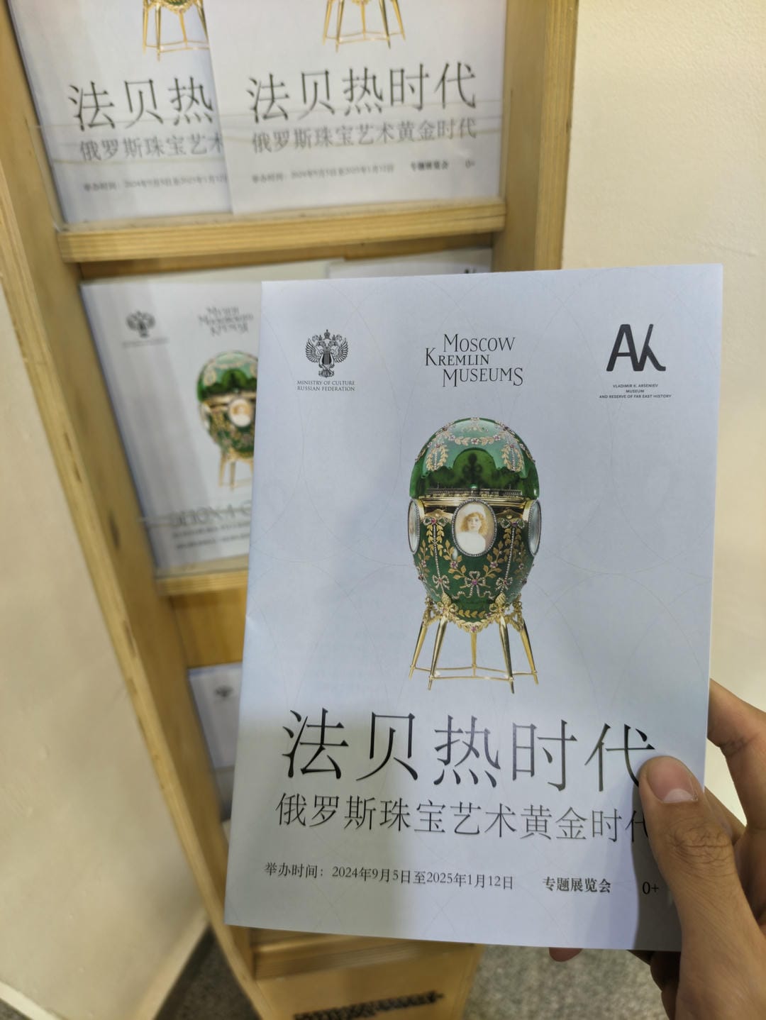 A hand holding a brochure titled “The Fabergé Era.”