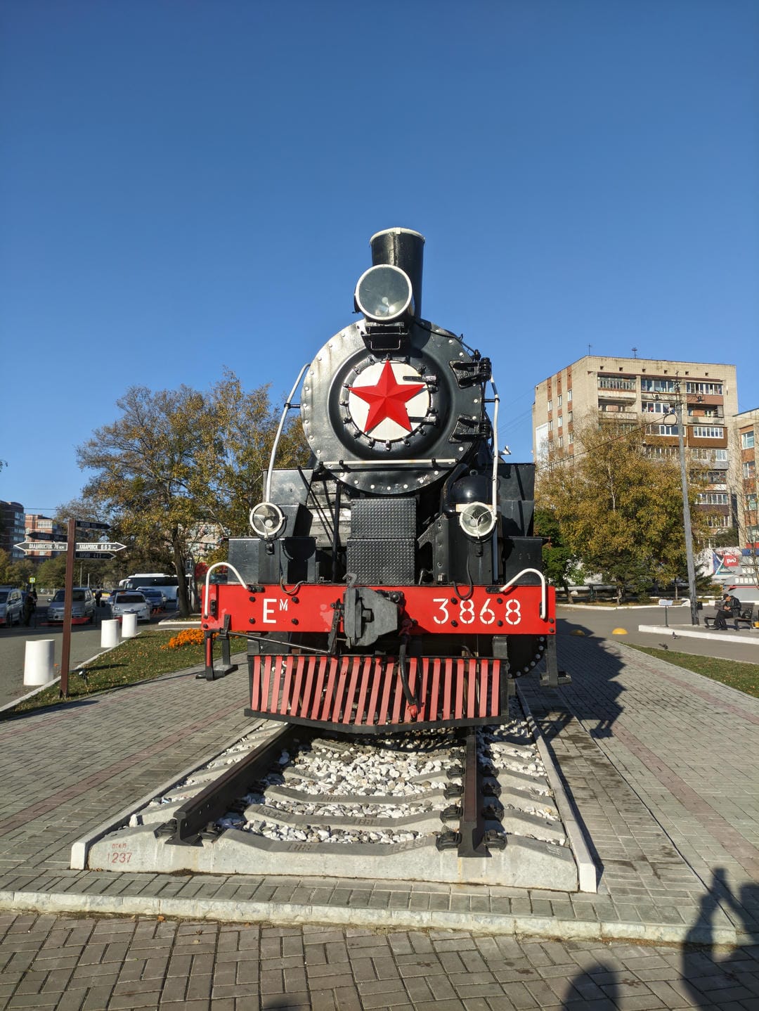 A black steam locomotive parked on the tracks, with a red star emblem on the front and the license plate number 386.8.