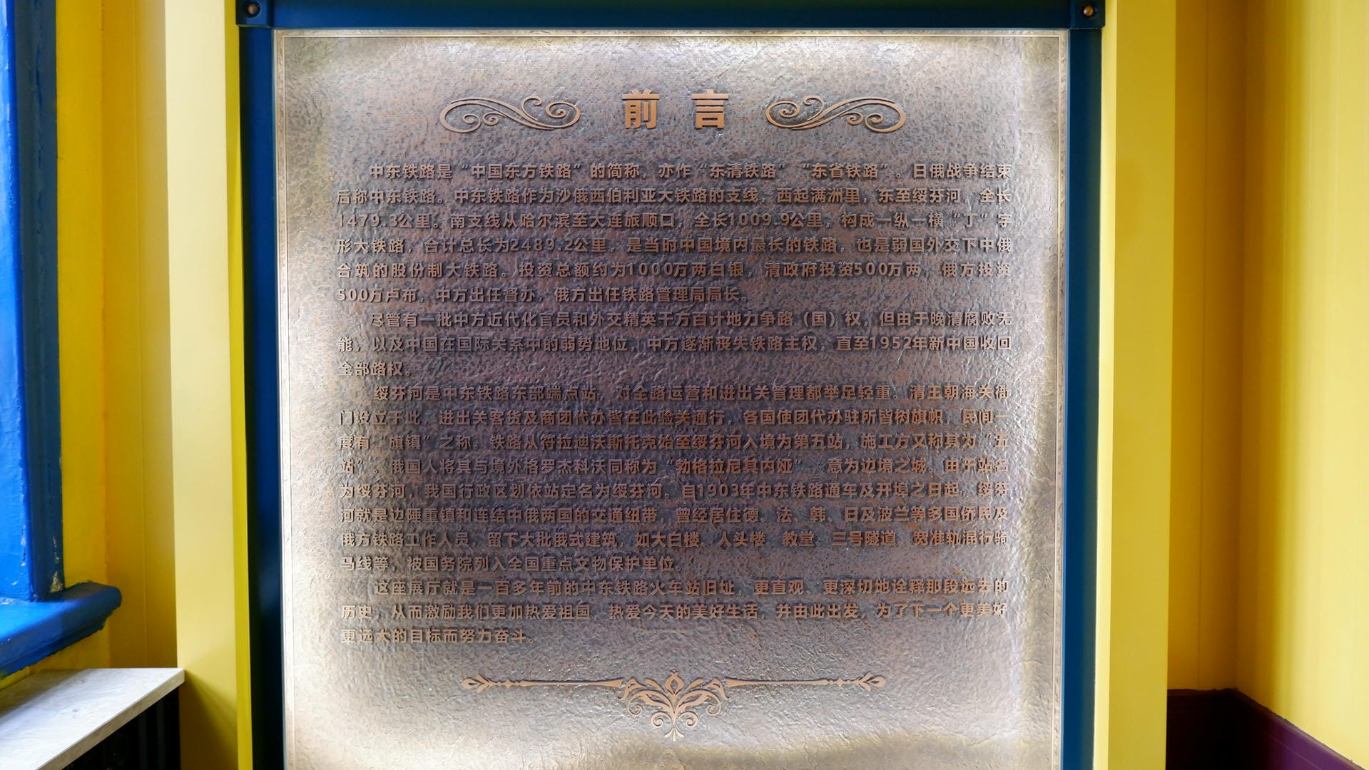 A metal plaque with a golden frame, inscribed with an introduction to the history of the Middle East Railway in Chinese.