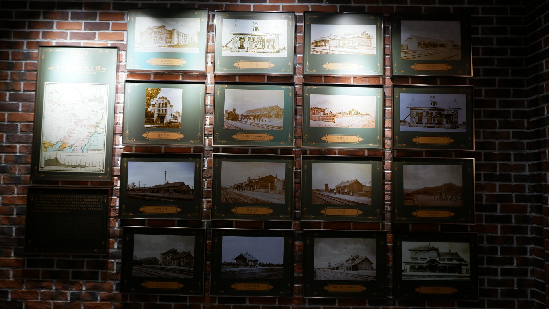 Numerous framed historical photos are neatly arranged on a red brick wall, each with a label underneath.