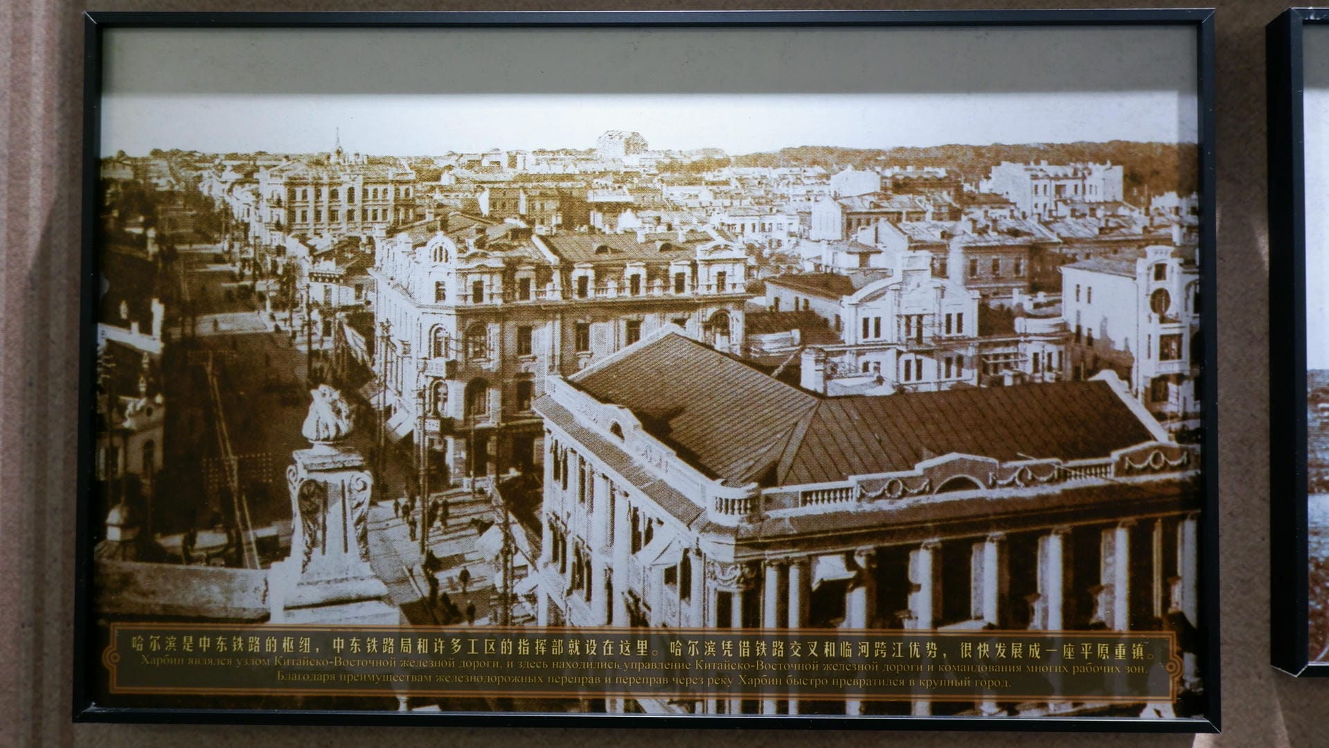 A black-and-white old photograph shows an aerial view of the city, with an explanatory text below.