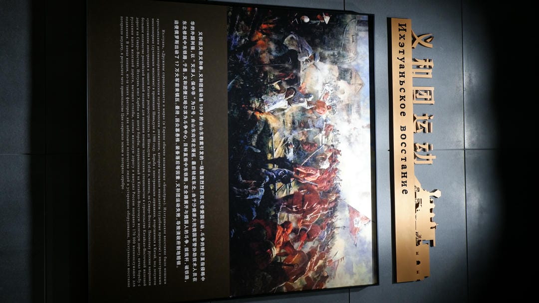 A painting of the Boxer Rebellion hangs on the wall, with titles in both Chinese and Russian above.