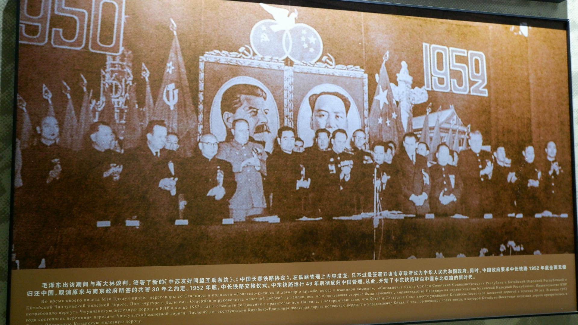 A historical mural depicts a scene from 1952, featuring flags and figures.