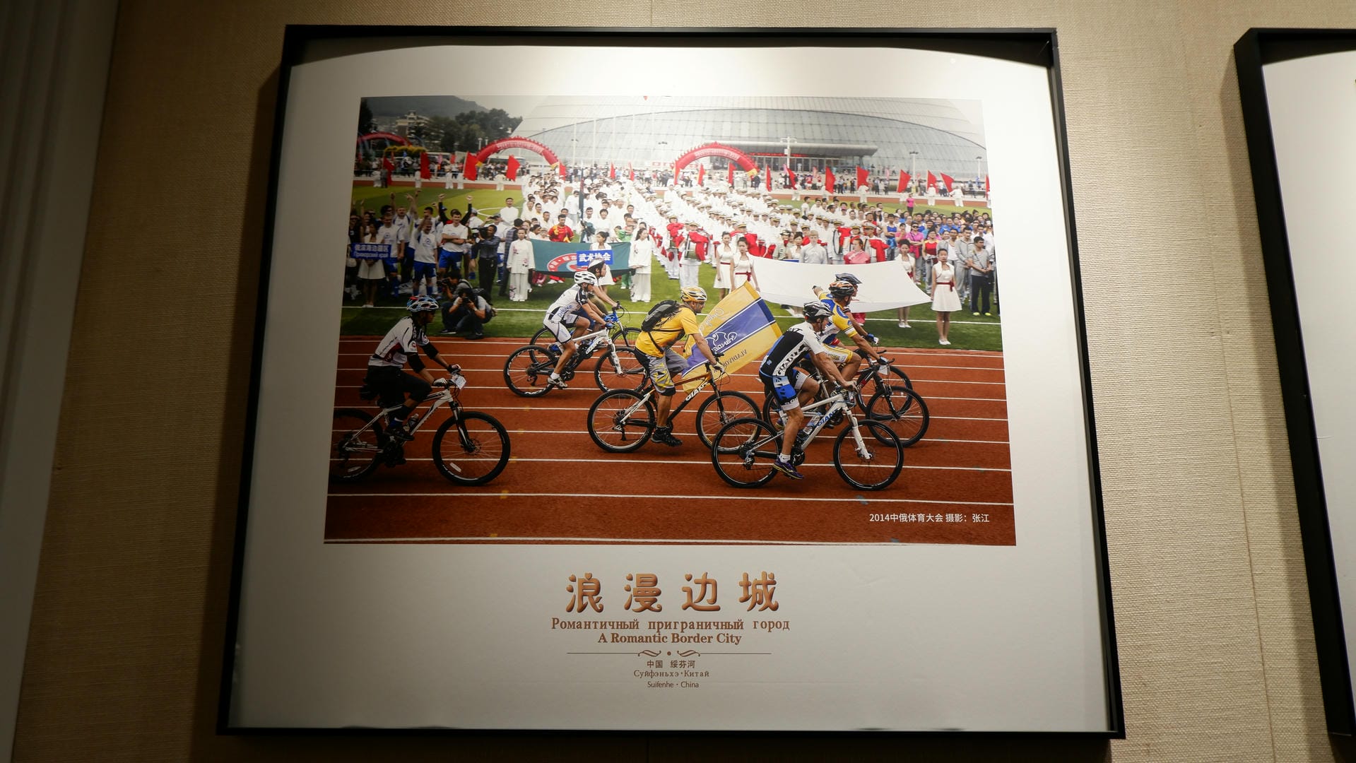 A painting shows a bicycle race scene, with spectators watching from the side.