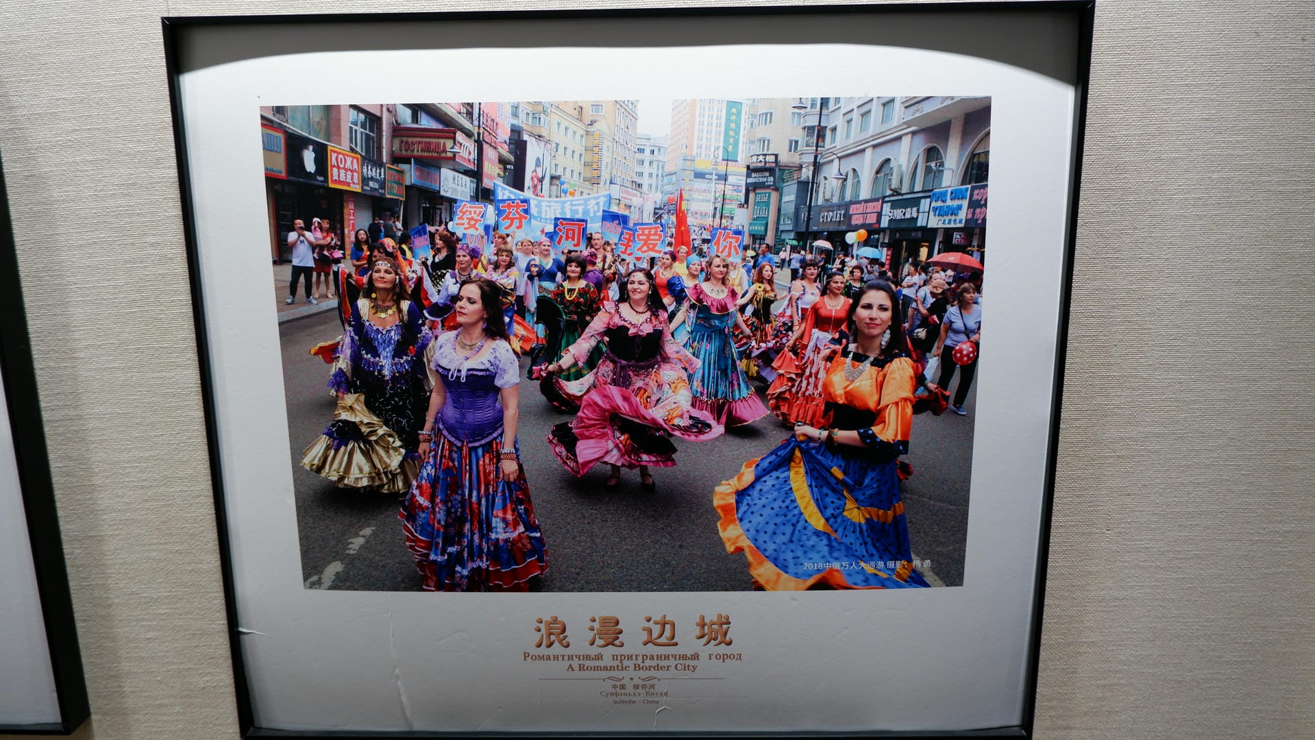 A painting depicts a street dance performance, with participants wearing colorful costumes.
