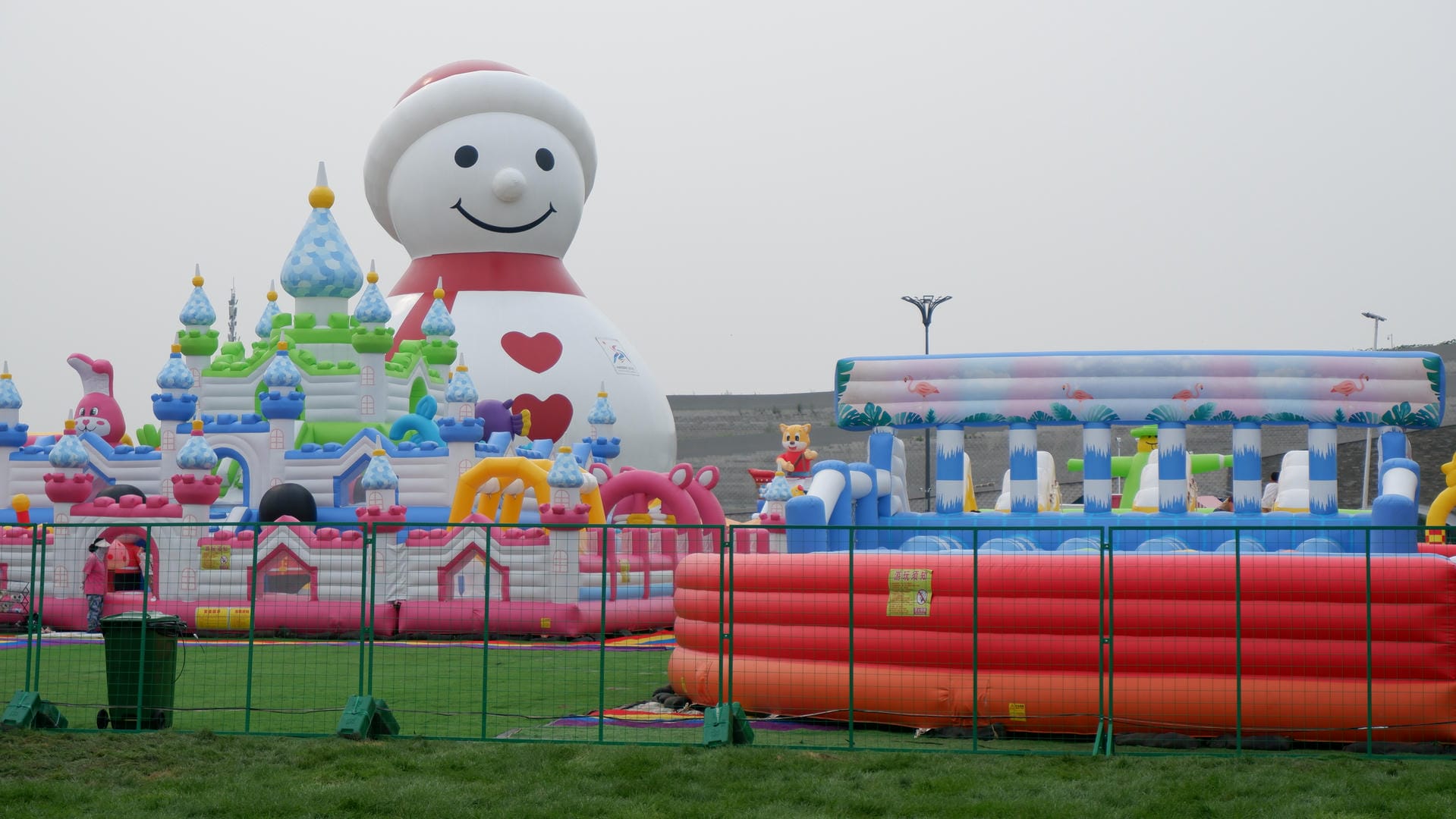 there is a large inflatable snowman in a park with a castle in the background